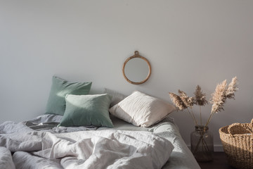 Schlafzimmer mit Bett und Spiegel an der Wand, Korb und Dekoration