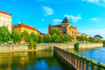 Fototapeta premium The Bellevue house and wooden protective structures on the banks of the Vltava River in Prague, in the Czech Republic. The Charles Bridge