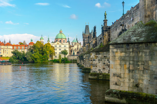 Charles Bridge in Prague in the Czech Republic. Catholic church of St. Franciszek of Serafin. Sculptures on the Charles Bridge. The Vltava River