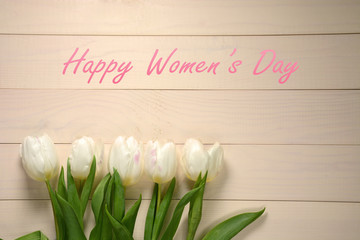 Womens Day card. White tulips on wooden background