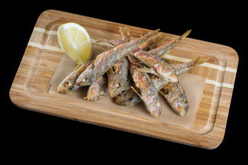 Fried scad on a wooden board