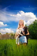 Beautiful country girl with a small goat in her hands