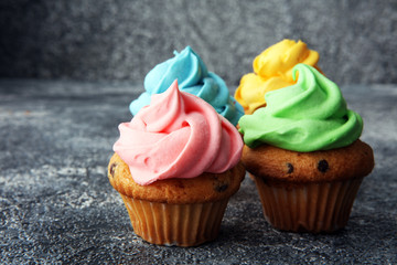 Tasty cupcakes on grey background. Birthday cupcake in rainbow colors