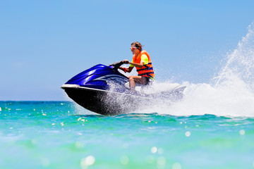 Teenager on jet ski. Teen age boy water skiing.