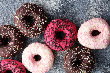 donuts in different glazes on grey background. birthday bakery concept
