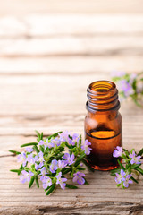 Rosemary massage oil and flowers on the wooden table