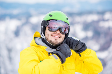 Man wearing sports helmet during the winter vacations snowboarding on the mountains