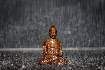 Betende Buddha Statue aus Holz im Regen