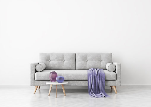 Living room interior with grey velvet sofa, violet plaid, vases and coffee table on empty white wall background. 3D rendering.