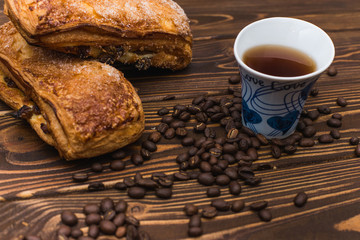 Puff pastry with a cup of tea on a wooden background.