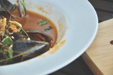 selective focusing of Spicy mussel, appetizer traditional food, tastes of Thai food in Thailand restaurant.