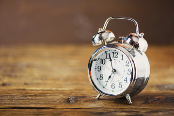 A Black Retro alarm clock on wooden board