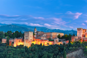Palace and fortress complex Alhambra with Comares Tower, Palacios Nazaries and Palace of Charles V during evening blue hour in Granada, Andalusia, Spain