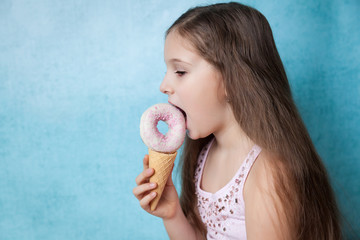 Happy girl is having fun with donut