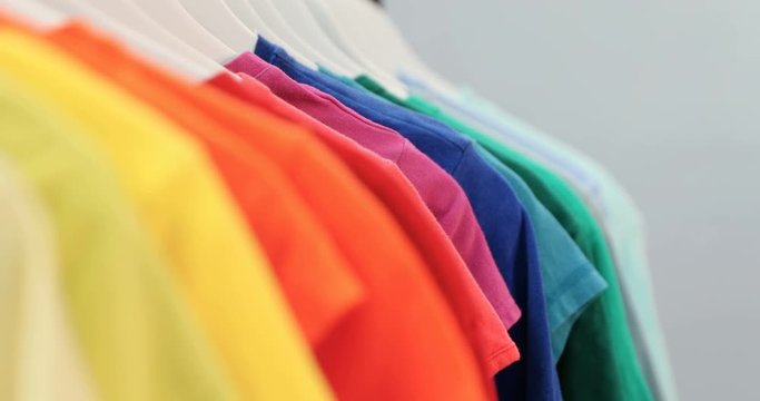 Various t-shirts arranged in a row on cloth rack 