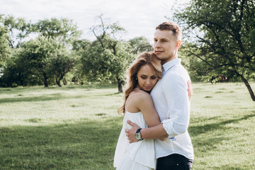 Fototapeta premium Young happy couple hugging each other on the nature on a sunny day
