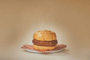 A Steaming Plastic Hamburger on a Plate with Checkered Napkin