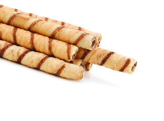 Heap of striped wafer tubules with the chocolate cream, isolated