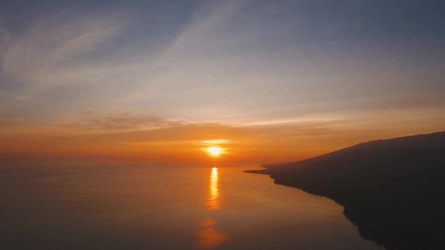 Sea coast at sunset. Aerial view of sunset on the ocean coast, sea, beach, sky, clouds. Bali, Indonesia. Sunset on the island of Bali. 4K, Aerial footage
