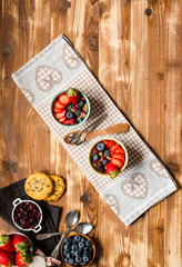 Fototapeta na wymiar Cereal. Breakfast with muesli, and fresh fruits in bowls on a rustic wooden background,