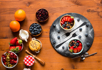 Cereal. Breakfast with muesli, and fresh fruits in bowls on a rustic wooden background,