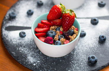 Cereal. Breakfast with muesli, and fresh fruits in bowls on a rustic wooden background,