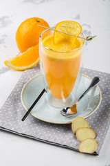 A glass of tea with orange and ginger