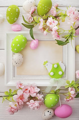 easter greeting card. empty photo frame. easter eggs and flowers