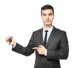 Handsome car salesman with key on white background