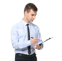 Handsome car salesman writing on clipboard against white background