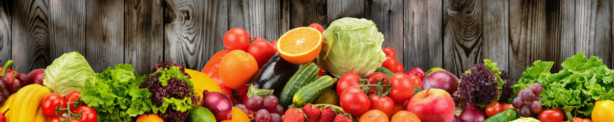 Fruits and vegetables on background of wooden wall. Healthy vegetarian food.