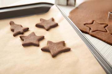 Cutting cookies from raw dough on table
