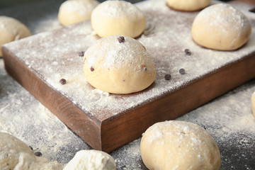 Unbaked buns of dough on table