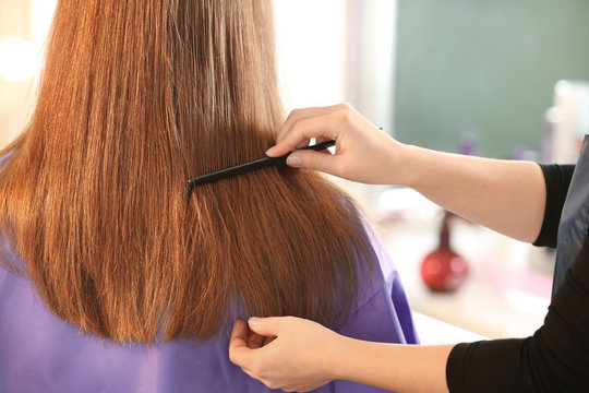 Professional hairdresser working with client in salon