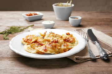 Plate with tasty dumplings on table