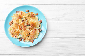Plate with tasty dumplings on wooden background