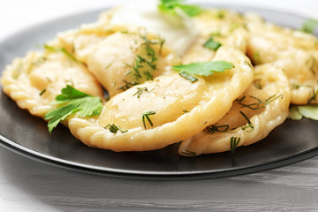 Plate with tasty dumplings on table, closeup