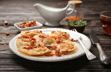 Plate with tasty dumplings on table