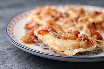 Plate with tasty dumplings on table, closeup