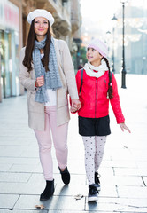 positive woman with daughter walking