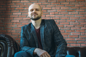 Young handsome guy seating, smiling and looking at camera