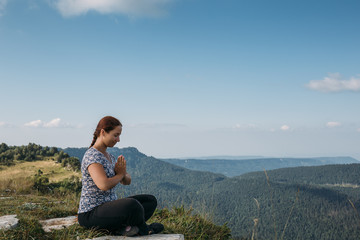 Naklejka na ściany i meble Young girl or woman relax or meditate in mountains