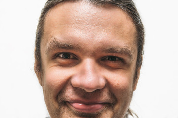 Obraz premium Funny smiling man with crazy eyes looking at camera on white background