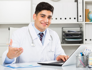 Obraz premium Cheerful doctor is doing report about patients