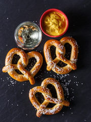 Pretzels and mustard on slate table
