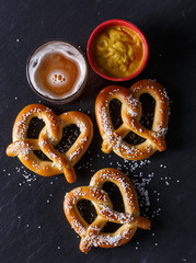 Pretzels and mustard on slate table