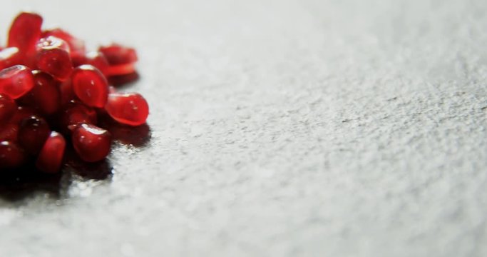 Pomegranate seeds on grey background  
