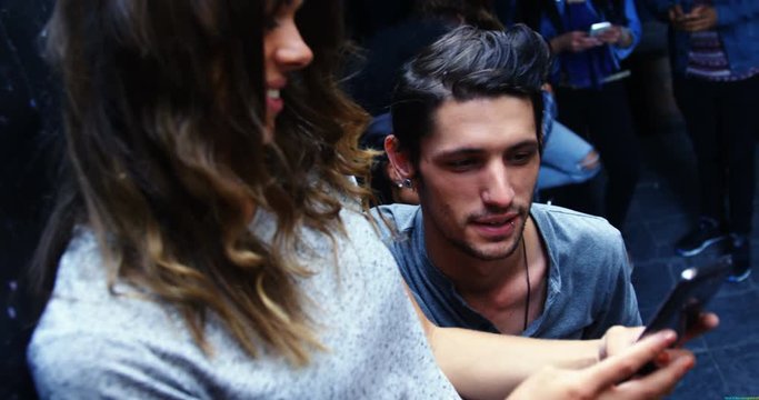 Young couple discussing over a mobile phone,  