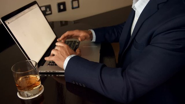 Mid section of businessman working on laptop 