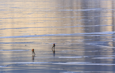 Two people skate on the ice of lake Baikal the view from the top